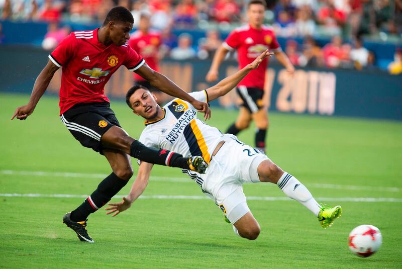 Manchester United Marcus Rashford, left, kicks the ball against Los Angeles Galaxy during the first half of a national friendly soccer game at StubHub Center on July 15, 2017 in Carson, California.   / AFP PHOTO / RINGO CHIU