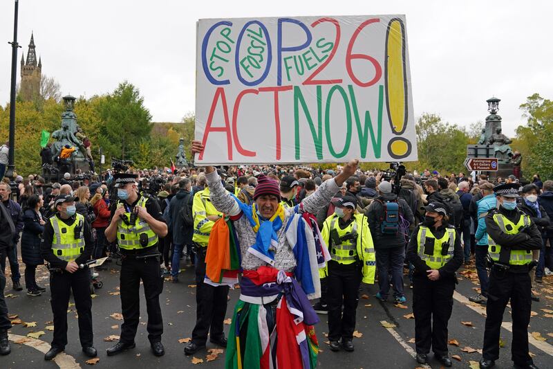 A demonstrator holds a placard calling on the Cop26 summit to 'Act Now'. PA