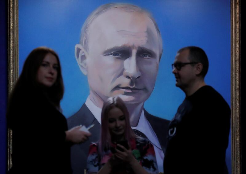 REFILE - REMOVING RESTRICTIONS People stand in front of a painting depicting Russian president Vladimir Putin at the "SUPERPUTIN" exhibition in UMAM museum in Moscow, Russia, December 6, 2017. REUTERS/Maxim Shemetov