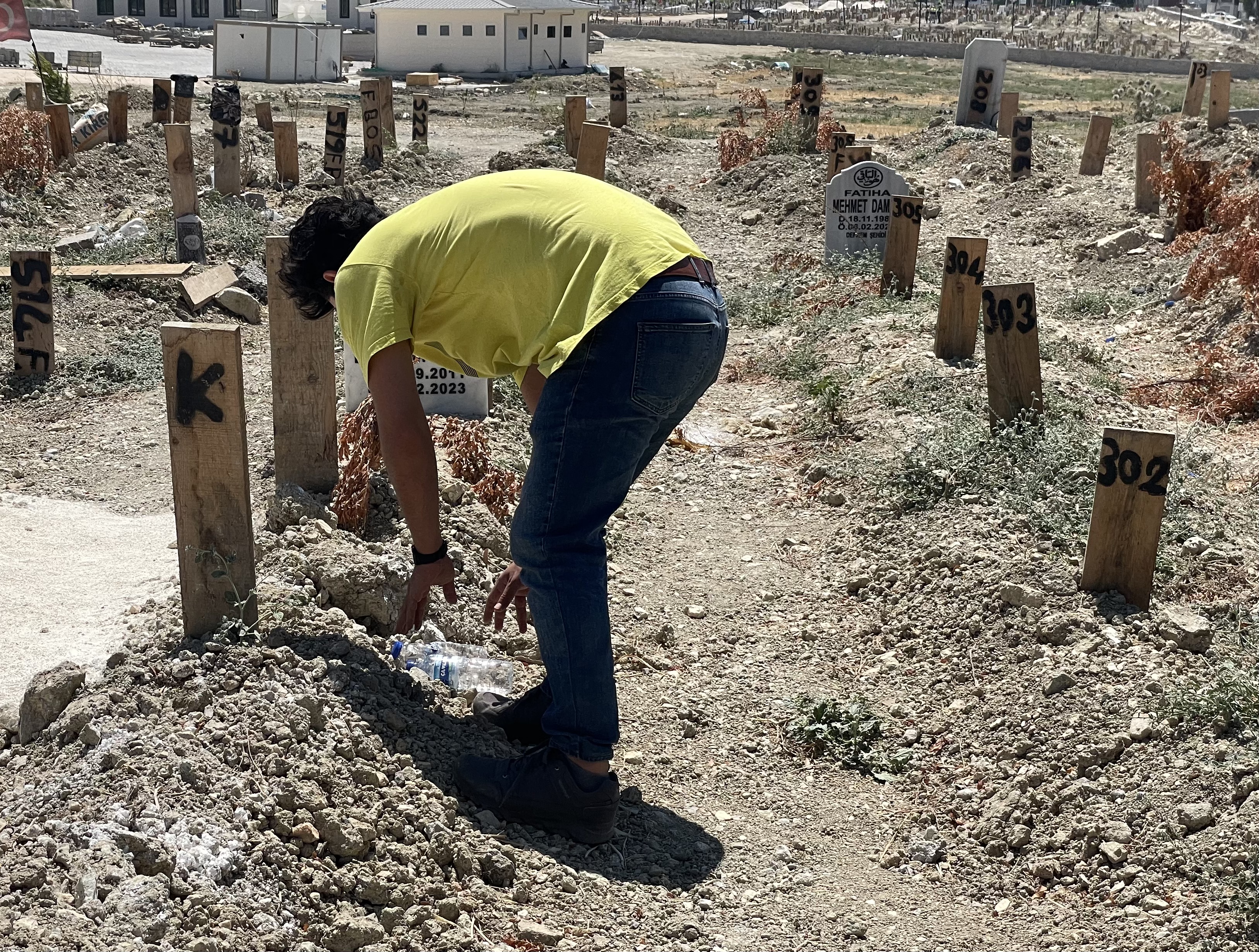 A Syrian man pours water over the grave of his friend at a cemetery for victims of the February 6 earthquake, near the city of Hatay, south-west Turkey. photo: Khaled Yacoub Oweis / The National
