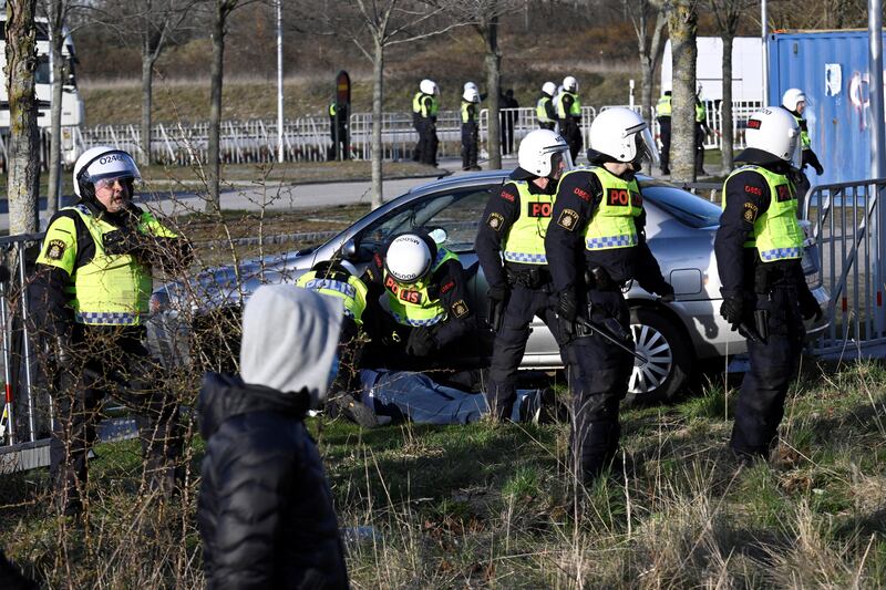 Police detain a driver who drove a car into roadblocks where Rasmus Paludan, leader of Danish far-right political party Hard Line, was holding a demonstration, at Skanegarden, near Malmo. Reuters