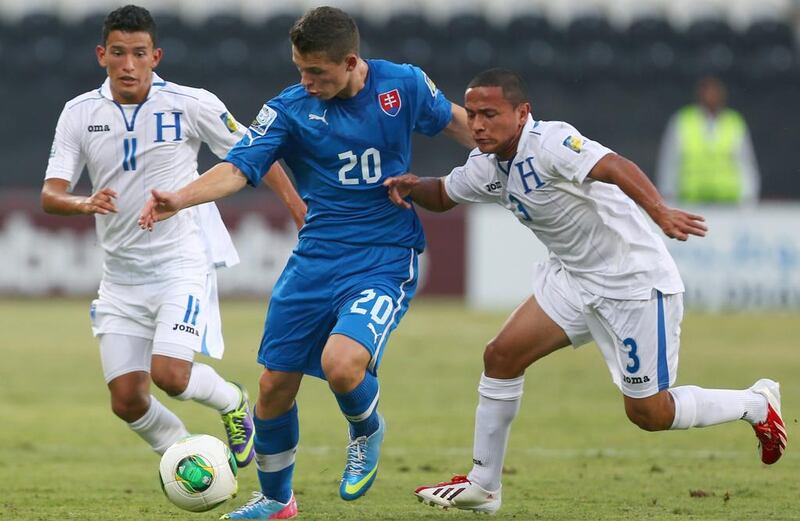 Nikolas Spalek, centre, of Slovakia, vies for the ball against Alvaro Romero, right, and Rembrant Flores of Honduras during their Fifa U17 World Cup at the Mohammad Bin Zayed Stadium in Abu Dhabi.  Marwan Naamani / AFP