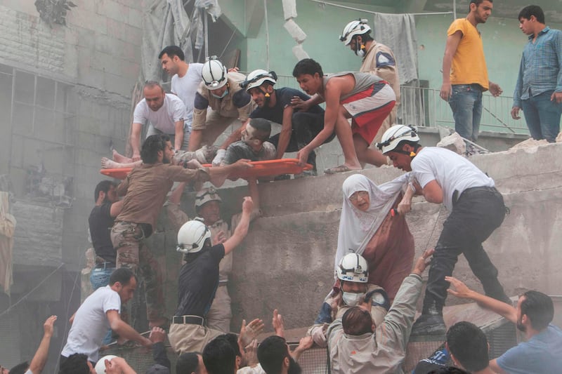 (FILES) This file photo taken by Karam al-Masri on June 9, 2015 shows Syrian rescue workers and citizens evacuating people from a building following a reported barrel bomb attack by Syrian government forces on the central al-Fardous rebel held neighbourhood of the northern Syrian city of Aleppo.
Journalist Karam al-Masri was wounded multiple times and detained by both the Syrian government and the Islamic State group, but still yearns to return to conflict reporting. Masri, who on November 9, 2017 will receive the Knight International Journalism Award in Washington, worked to bring the pain, suffering and destruction wrought on Syria's Aleppo to the world's attention, first with a camera phone and later working for AFP. / AFP PHOTO / KARAM AL-MASRI