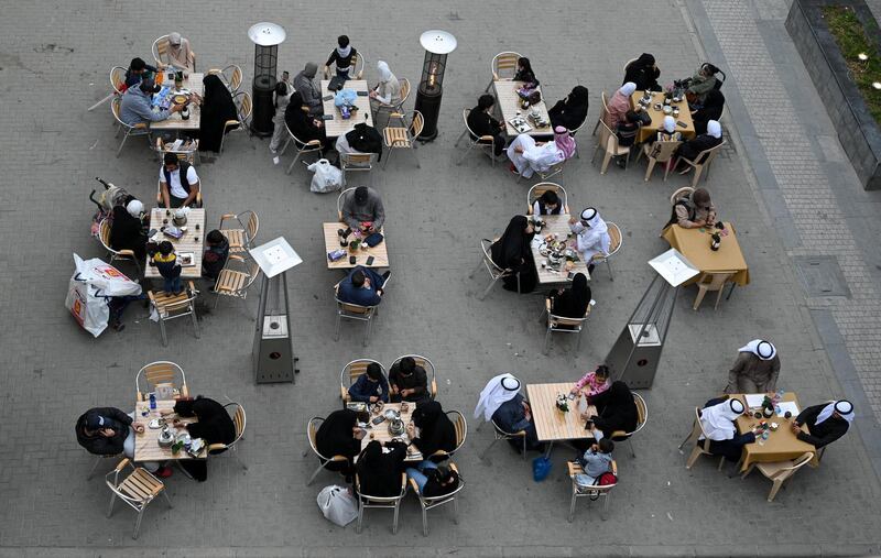 Customers sit at a traditional open-air coffee shop at Kuwait City's Souk Al Mubarakiya. From 24 February, eateries will only be able to offer takeaway services, due to Covid-19 restrictions. EPA