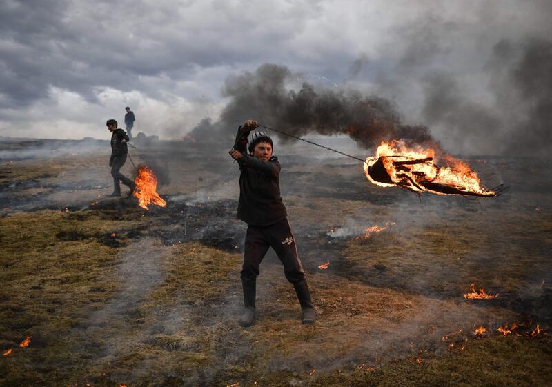 A Romanian youth spins a flaming tire as part of a tradition marking the upcoming Clean Monday, the first day of Great Lent in the Eastern Orthodox Christian church calendar. AFP