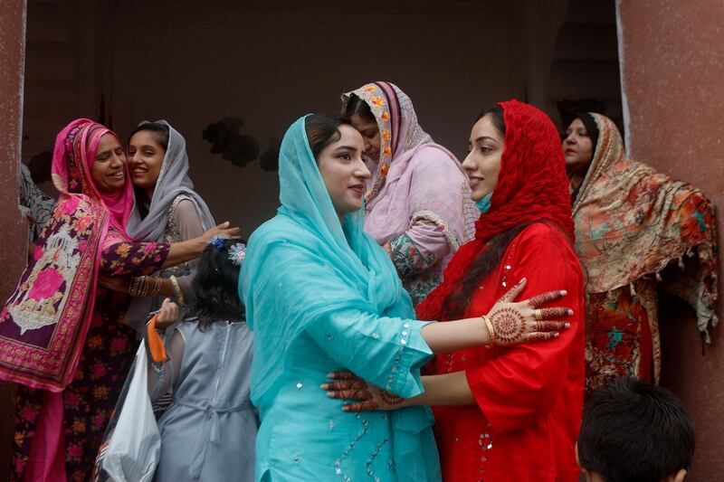 Women share Eid greetings after Eid al-Adha prayers at the historical Badshahi Mosque in Lahore, Pakistan, Saturday, Aug. 1, 2020. During Eid al-Adha, or Feast of Sacrifice, Muslims slaughter sheep or cattle and distribute portions of the meat to the poor. (AP Photo/K.M. Chaudary)