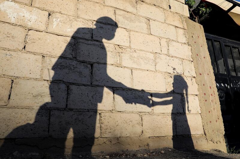 The shadow of a girl receiving a meal for iftar, or the evening meal, to break fast from a member of "Tkiyet Um Ali" humanitarian services centre is cast on a wall in front of her family home in the city of Russeifa in Jordan. Reuters