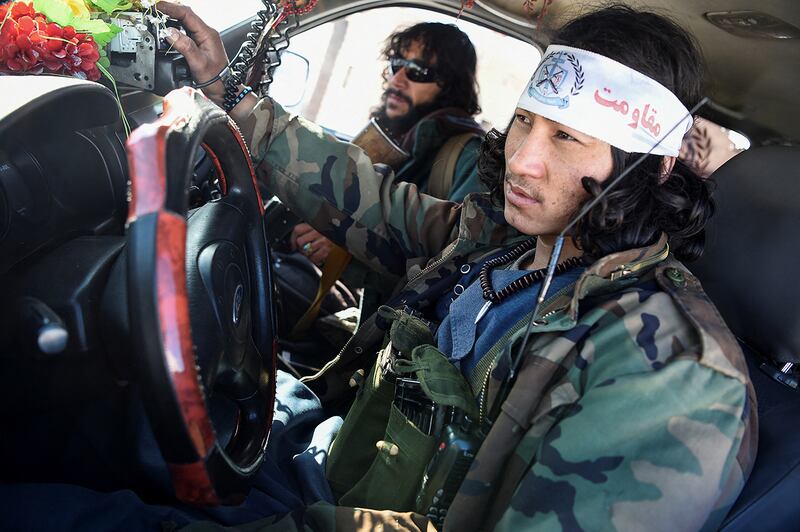 In this photo taken on January 9, 2021, Hazara armed militia for the Resistance for Justice Movement, sit in a car in front of their base during a patrol against Taliban insurgents at Hisa-e-Awali Behsud district of Maidan Wardak Province. - Comprising roughly 10 to 20 percent of Afghanistan's 38-million population, Hazaras have long been persecuted for their largely Shiite faith by Sunni hardliners in a country wracked by deep ethnic divisions. (Photo by WAKIL KOHSAR / AFP) / TO GO WITH'Afghanistan-Hazara-violence', by David STOUT, Najiba NOORI