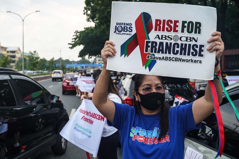Employees and supporters of the ABS-CBN network hold placards as they protest in front of the House of Representatives in Manila. AFP