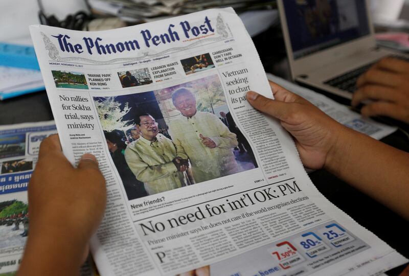 A man holds a newspaper that shows a picture of Cambodia's Prime Minister Hun Sen, who shakes hands with U.S. President Donald Trump during a gala dinner at the ongoing ASEAN Summit in Manila, in Phnom Penh, Cambodia, November 13, 2017. REUTERS/Samrang Pring  NO RESALES. NO ARCHIVES