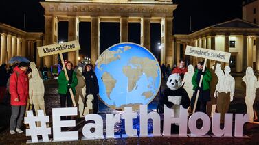 Activists stand in front of the Brandenburg Gate to mark Earth Hour in Berlin, Germany. EPA