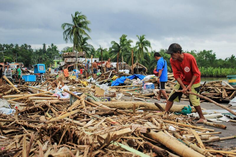 Residents gather debris from their destroyed houses after Typhoon Kammuri hit the city of Sorsogon, south of of Manila.  AFP
