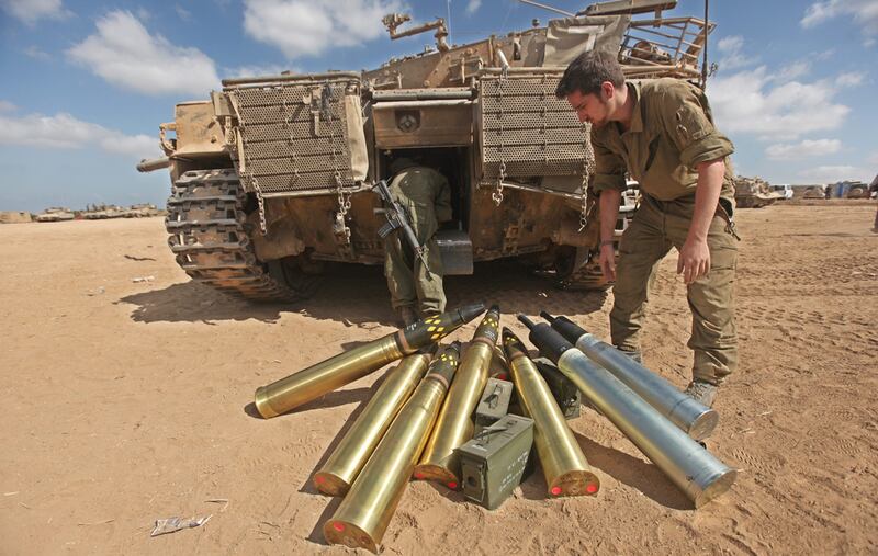An Israeli soldier loads ammunition onto a tank at an unspecified location at the border between the Gaza Strip and Israel.  EPA