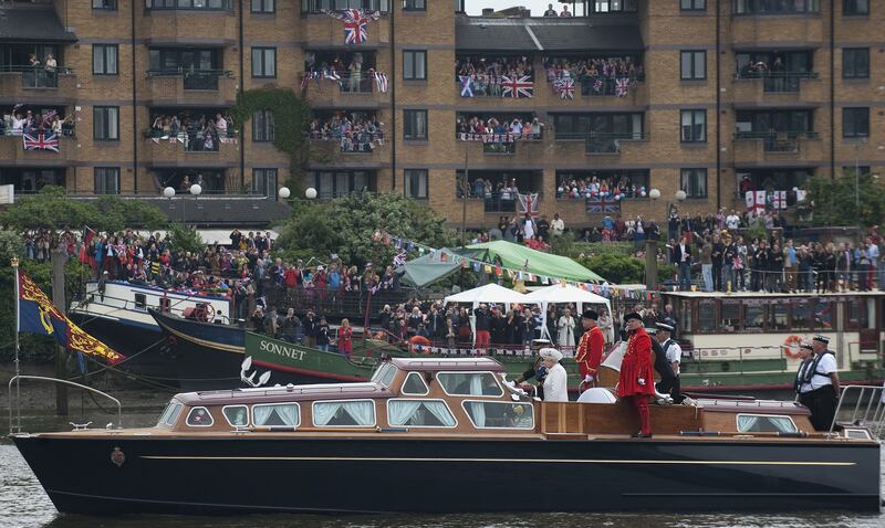 Members of the public cheer and wave flags as Queen Elizabeth and Prince Philip embark from Chelsea Harbour in London on the first part of their jubilee river pageant to celebrate the diamond jubilee in June 2012.