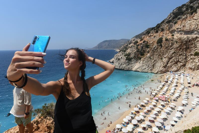 A woman pose for a selfie in Kaputas beach  in Kas, Turkey.  Getty Images