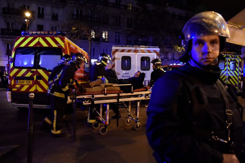 (FILES) This file photo taken on November 14, 2015 shows rescuers workers evacuating a man on a stretcher near the Bataclan concert hall in central Paris as a number of people were killed and others injured in a series of gun attacks across Paris, as well as explosions outside the national stadium where France was hosting Germany. 
November 13, 2017 marks the second anniversary of the coordinated jihadist attacks at the Bataclan concert hall and several bars and restaurants in Paris and at the stadium in Saint-Denis, which killed 130 people and left more than 350 injured. / AFP PHOTO / DOMINIQUE FAGET