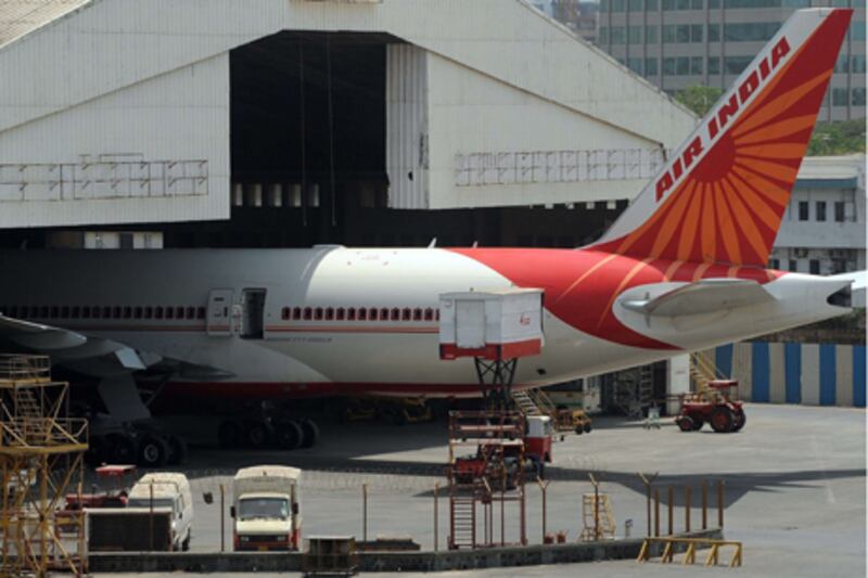 A jeep goes past an Air India aircraft parked at Chattrapati Shivaji International airport in Mumbai on May 8, 2012. At least 100 pilots from India's debt-laden national carrier Air India failed to turn up to work in a move the civil aviation minister described as an "illegal" strike.  The airline, which loses nearly USD 2 million a day, is facing mounting problems due to rising fuel prices, competition from low-cost rivals and a record of labour disputes. AFP PHOTO/Indranil MUKHERJEE