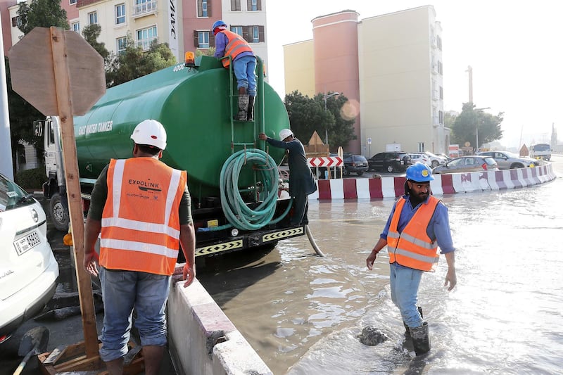 DUBAI , UNITED ARAB EMIRATES , JAN 09 – 2018 :- Workers at the under construction Dubai Metro site pumping out the rain water with the help of water tankers at street 5 in Discovery Gardens area in Dubai.  (Pawan Singh / The National) For News. 
