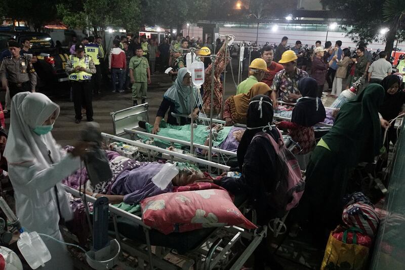 Patients are evacuated to a parking lot outside a damaged hospital after an earthquake hit the city of Banyumas, Central Java, Indonesia. Idhad Zakaria / Antara Foto via Reuters