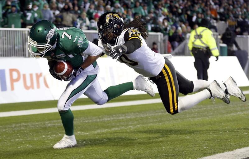 The Saskatchewan Roughriders Weston Dressler, left, scores a touchdown ahead of a last-ditch tackle from the Hamilton Tiger-Cats Rico Murray during the second half. Mark Blinch / Reuters