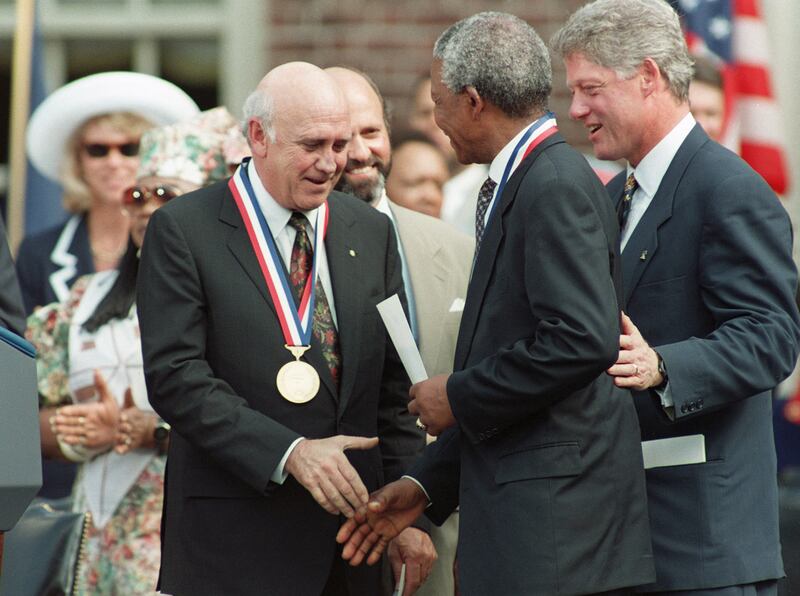 Former South African president FW de Klerk shakes hand with his successor, Nelson Mandela, as then US president Bill Clinton looks on in Washington in 1993. AFP