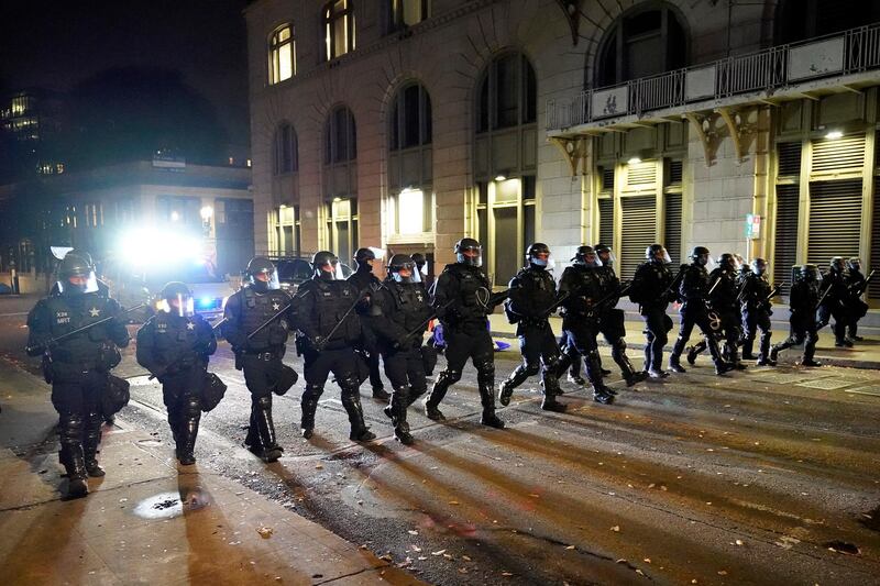 Police officers follow protesters in Portland, Oregon. AP Photo