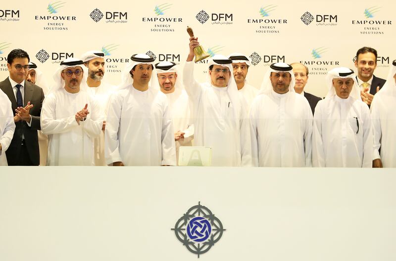 Saeed Al Tayer, managing director and chief executive of Dewa (centre) ringing the bell to mark the start of trading of Empower on the Dubai Financial Market. Pawan Singh / The National