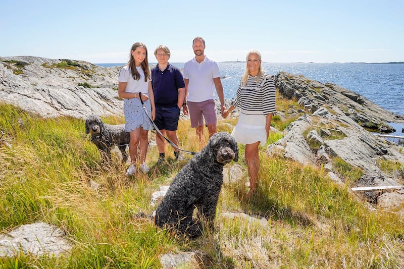 Norway's Crown Prince Haakon (2nd R), Crown Princess Mette-Marit (R), Prince Sverre Magnus (2nd L) and Princess Ingrid Alexandra (L) pose with their dogs  Milly Kakao (L) and Muffins Krakebolle (C) during their holiday on the island of Dvergsoya, near Kristiansand, on July 17, 2020. (Photo by Lise Åserud / NTB Scanpix / AFP) / Norway OUT
