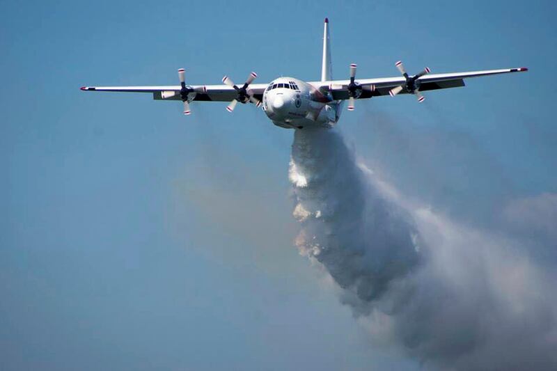 In this undated photo released from the Rural Fire Service, a C-130 Hercules plane called "Thor" drops water during a flight in Australia. Officials in Australia on Thursday, Jan. 23, 2020, searched for a water tanker plane feared to have crashed while fighting wildfires. (RFS via AP)