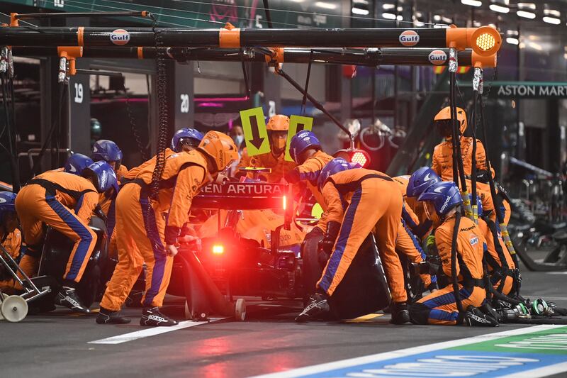 Mechanics work on the car of McLaren driver Lando Norris in the pits. AFP