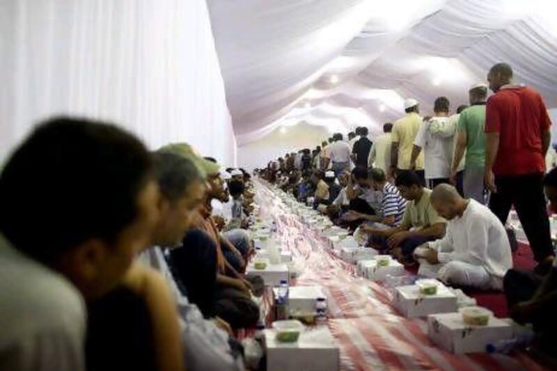 People prepare to share some of the 20,000 meals delivered every day during Ramadan to Muslims and non-Muslims in the iftar tents in the grounds of the Grand Mosque.