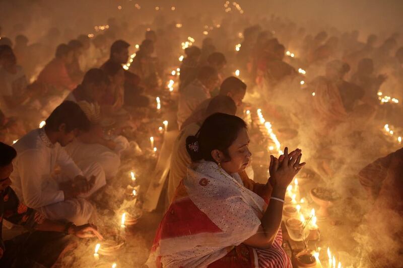 Hindu devotees attend a prayer with burning incense and light oil lamps before breaking fast during a religious festival called Rakher Upabash in Narayangonj, Bangladesh. The festival is celebrated in memory of the 18th century Hindu saint Baba Loknath. EPA