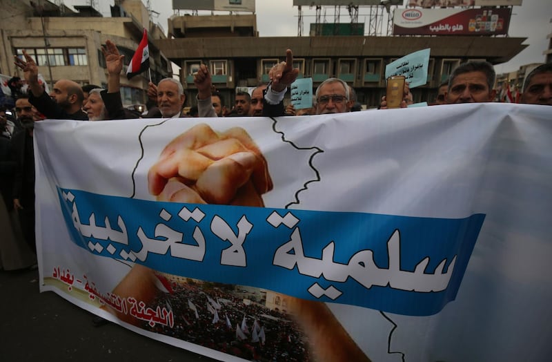 Iraqi demonstrators carry a large banner that says in Arabic "peaceful, not destructive" as they take part in an anti-govenment demonstration in the capital Baghdad's Tahrir Square. AFP