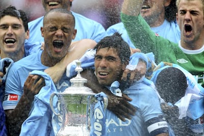 LONDON, ENGLAND - MAY 14:  Carlos Tevez of Manchester City and his team mates celebrate with the trophy after they won the FA Cup sponsored by E.ON Final match between Manchester City and Stoke City at Wembley Stadium on May 14, 2011 in London, England.  (Photo by Alex Livesey/Getty Images)