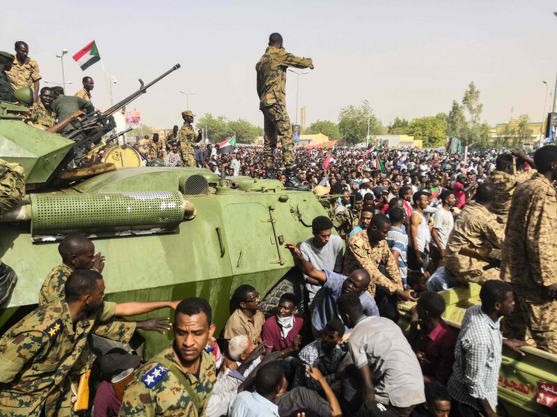 Sudanese soldiers stand guard on armoured military vehicles as demonstrators continue their protest against the regime near the army headquarters in the Sudanese capital Khartoum on April 11, 2019.  AFP