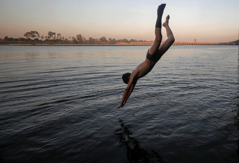 A boy jumps in the Nile River during hot weather on the outskirts of Cairo. Reuters