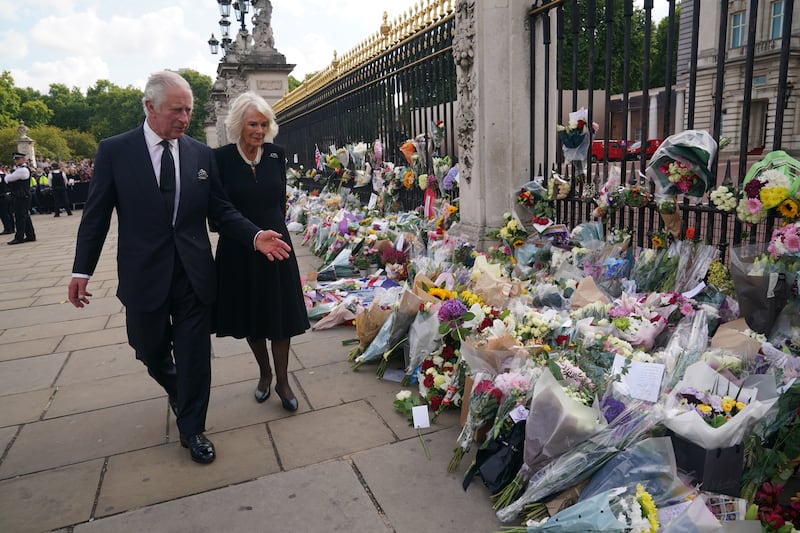 King Charles and the queen view floral tributes left outside Buckingham Palace after the death of Queen Elizabeth II in September 2022