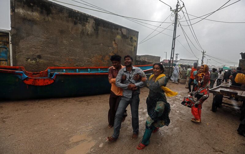 People takes a fisherman to hospital during rain as he got injured while moving a fishing boat to a safer place along the Arabian sea coast, as the Cyclone Vayu approaches Veraval, India.  EPA