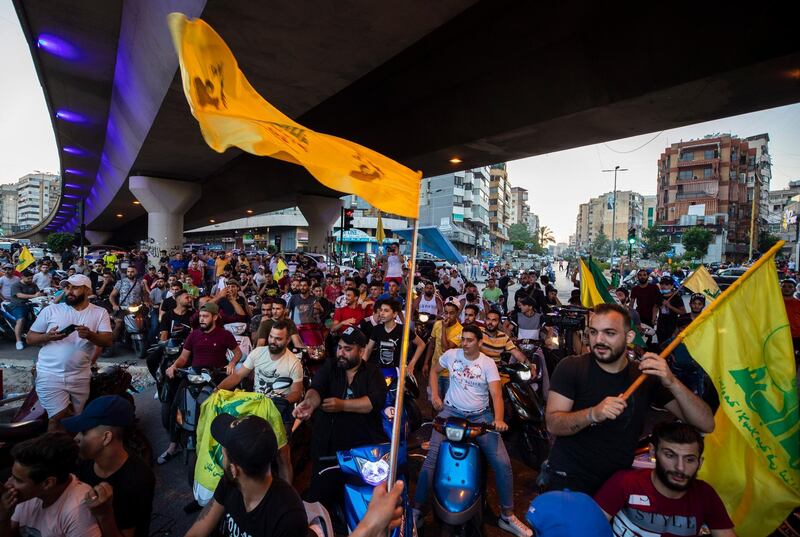 Hezbollah and Amal supporters wave Hezbollah flags as people shout slogans against Israel and US during a protest in the southern suburb of Beirut on June 28, 2020. AP