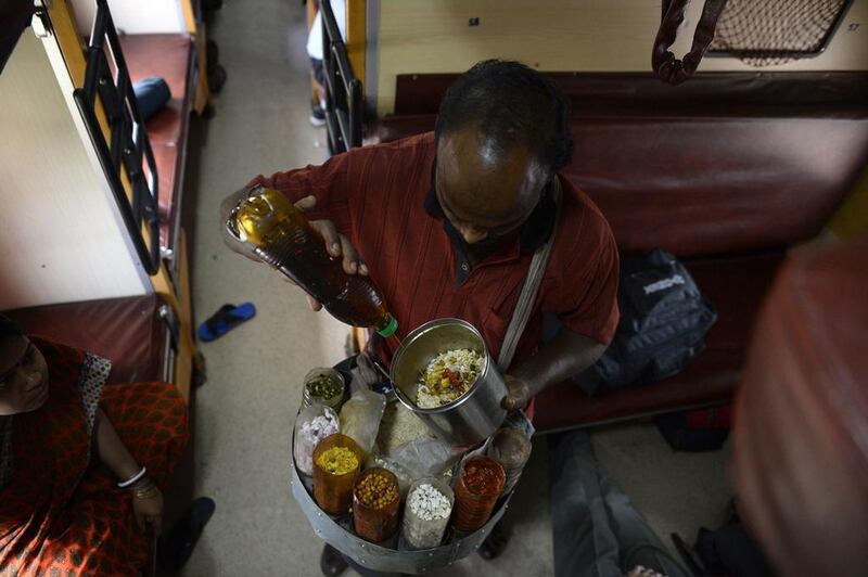 An Indian vendor sells snacks on board the Kalka Mail train.