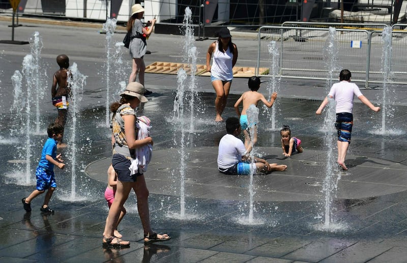 (FILES) In this file photo taken on July 3, 2018, women and children play in the water fountains at the Place des Arts in Montreal, Canada on a hot summer day. A heatwave in Quebec has killed at least 17 people in the past week as high summer temperatures scorched eastern Canada, health officials said on July 4, 2018. Twelve of the dead were reported in the eastern province's capital Montreal, said regional public health director Mylene Drouin.
 / AFP / EVA HAMBACH
