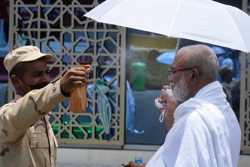 Saudi police officer sprays cold water on pilgrim at tent camp in Mina, near Makkah, on Monday. AP