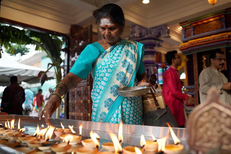 A Hindu lights up clay oil lamps. AP