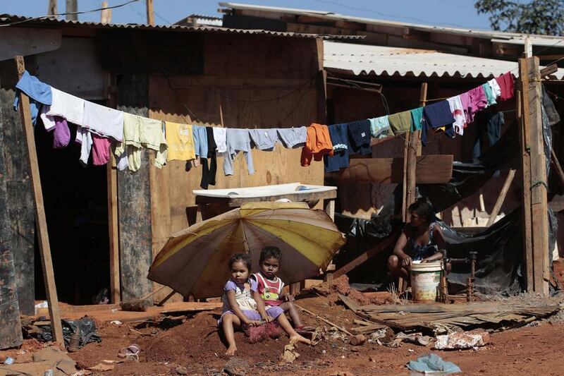 Two children sit in front of their home in the Santa Luzia slum, before the residents protest against the money spent on preparations of the upcoming World Cup, in Brasilia. The 2014 World Cup will be held in 12 cities in Brazil from June 12 till July 13. Joedson Alves / Reuters