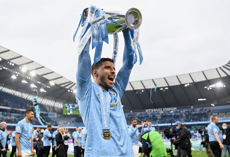 MANCHESTER, ENGLAND - MAY 23: Ruben Dias of Manchester City celebrates with the Premier League Trophy as Manchester City are presented with the Trophy as they win the league following the Premier League match between Manchester City and Everton at Etihad Stadium on May 23, 2021 in Manchester, England. A limited number of fans will be allowed into Premier League stadiums as Coronavirus restrictions begin to ease in the UK. (Photo by Michael Regan/Getty Images)