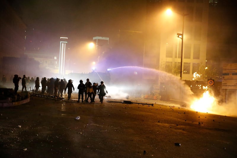 Lebanese riot police use a water cannon to extinguish a fire that was set by protesters in Beirut. AP Photo