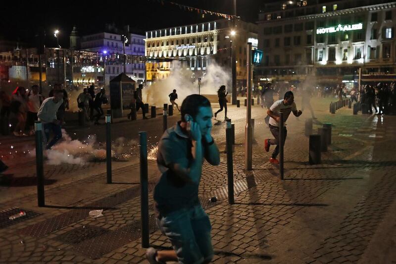 People run after police fired tear gas following clashes after the Euro 2016 soccer championship group B match between England and Russia in Marseille, France. Clashes between football fans Saturday in Marseille’s Old Port occurred for a third straight day of violence in the city. Darko Bandic / AP