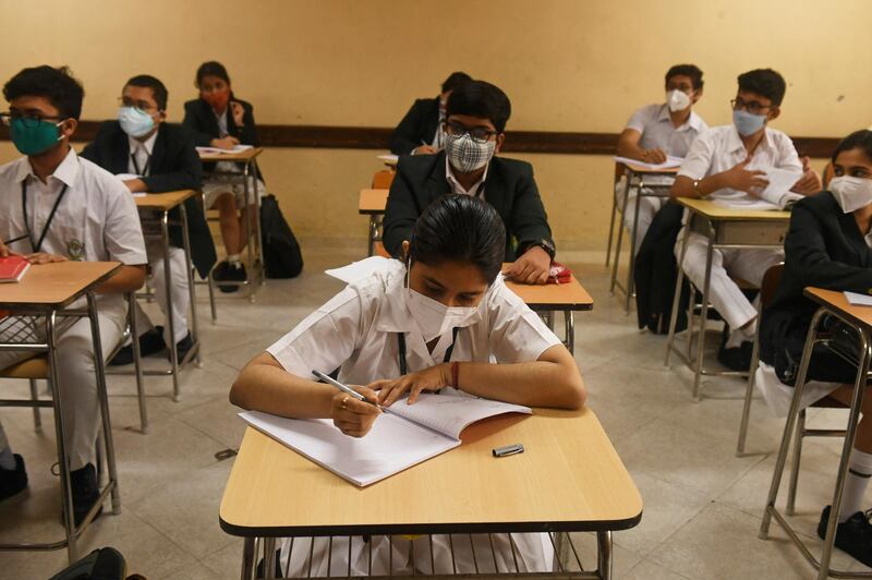 Schools students attend a class at a private school as the schools reopened after almost 11 months of break due to the Covid-19 coronavirus pandemic in Kolkata on February 12, 2021. (Photo by Dibyangshu SARKAR / AFP)