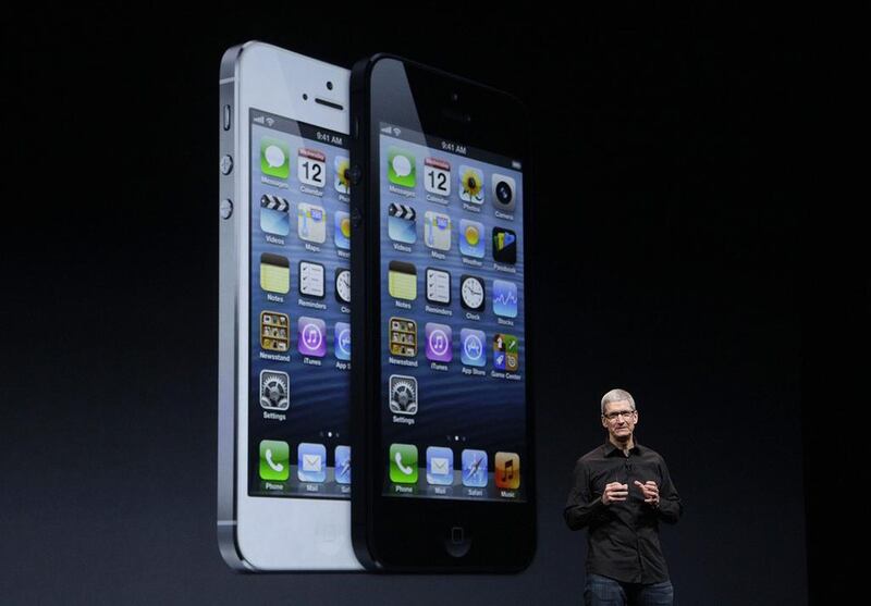 Apple CEO Tim Cook speaks in front of an image of the iPhone 5. Jeff Chiu / AP Photo