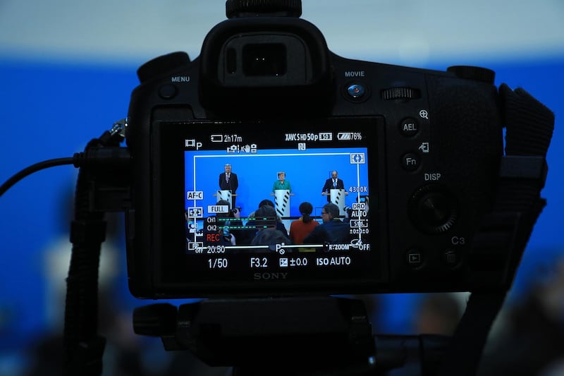 Horst Seehofer, leader of the Christian Social Union (CSU) party, left, Angela Merkel, Germany's chancellor and leader of the Christian Democratic Union (CDU) party, center, and Martin Schulz, leader of the Social Democrat Party (SPD), sit in a camera's viewfinder during a news conference at the CDU headquarters in Berlin, Germany, on Wednesday, Feb. 7, 2018. Merkel’s bloc has concluded a coalition agreement with the Social Democratic Party, ending a four-month political stalemate in Europe’s largest economy. Photographer: Krisztian Bocsi/Bloomberg